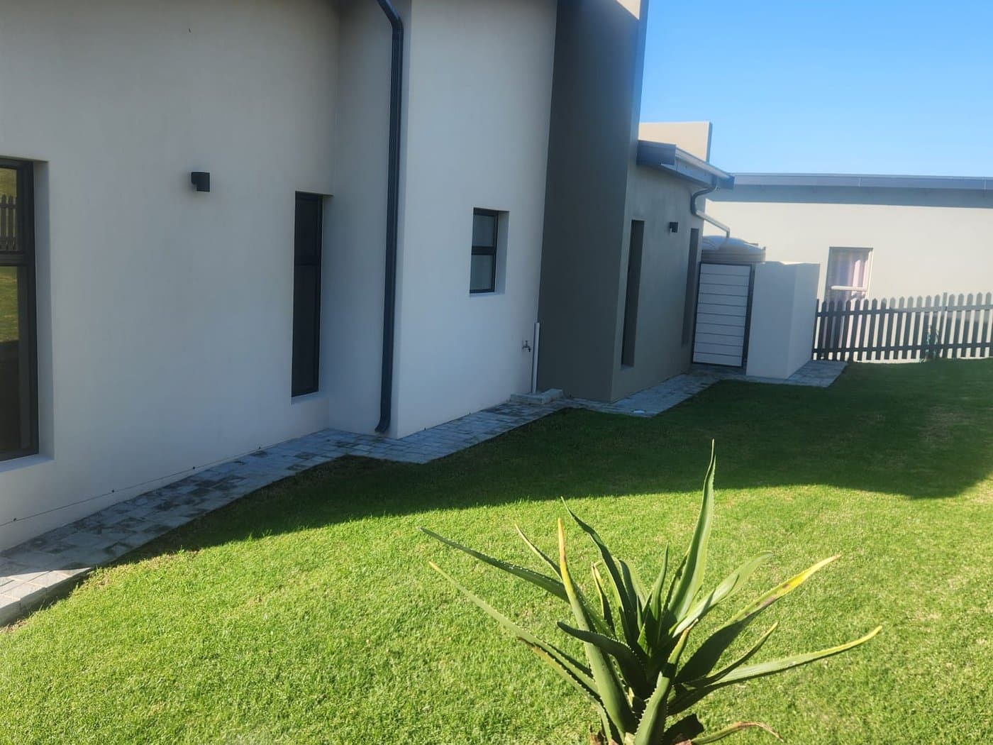 The finished side elevation of a home with an established lawn