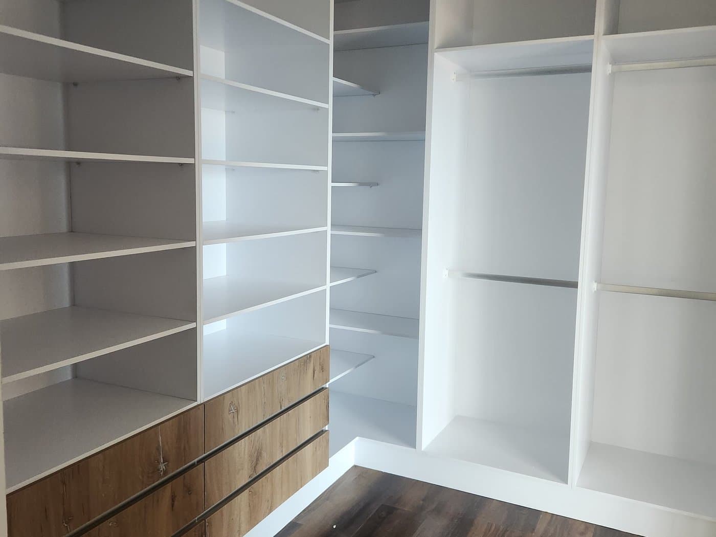 Built-in white shelving and cupboards fitted into an alcove