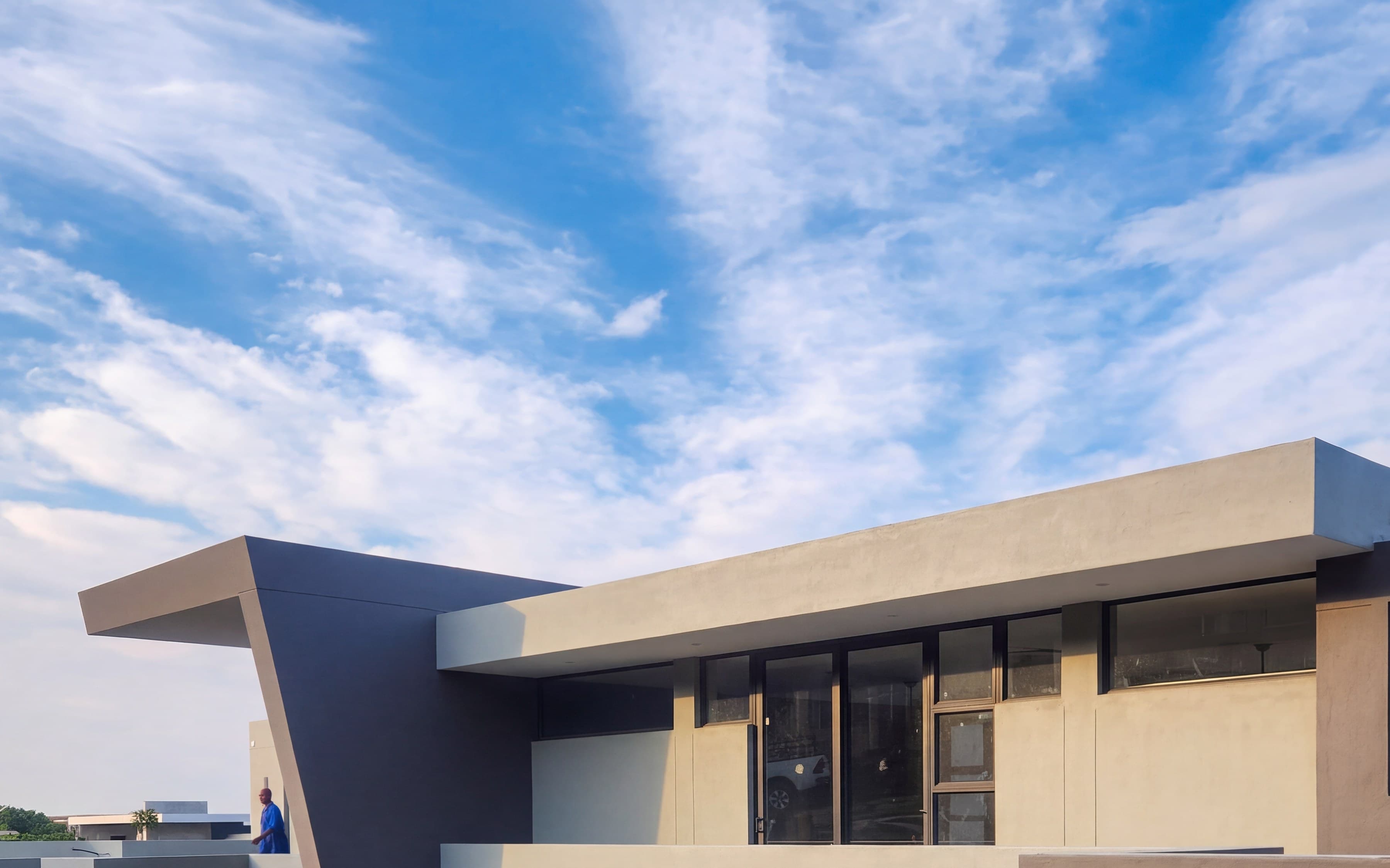 A completed two storey home by A-Tech Building Contractors in George: a deep cantilevered roof over a charcoal blade wall, under an open sky
