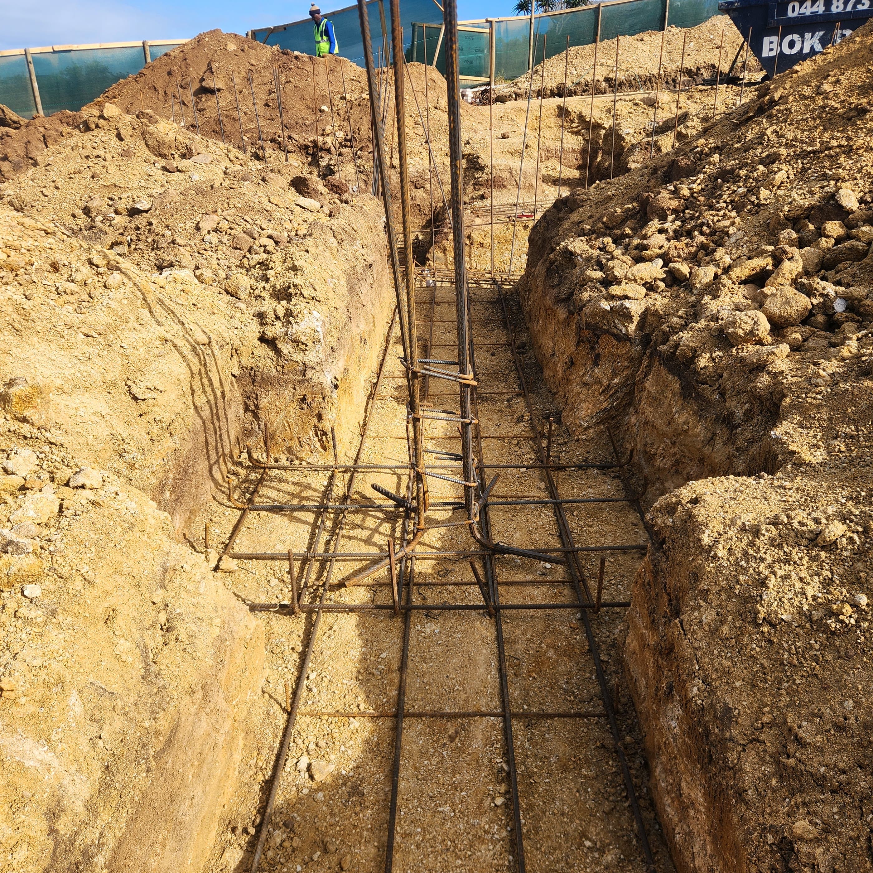A foundation trench with reinforcing cages set out and tied