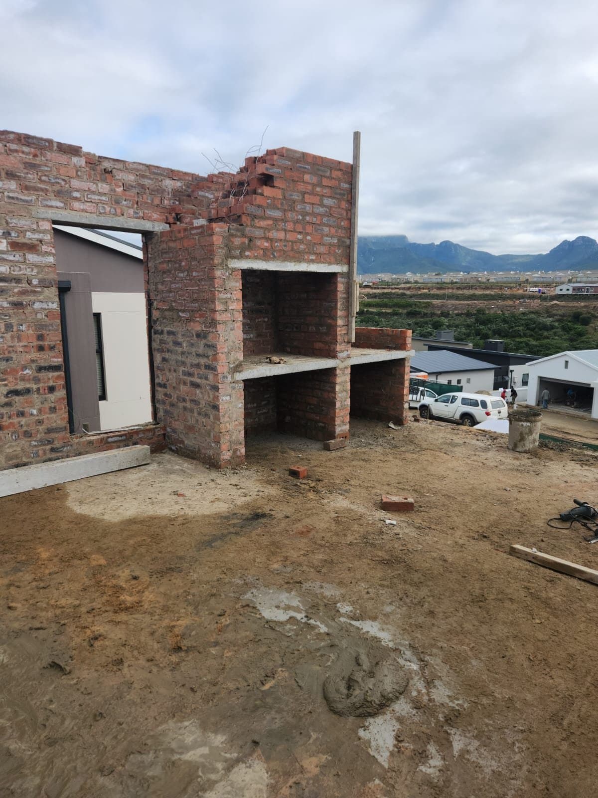 A face brick braai built into a wall, under construction